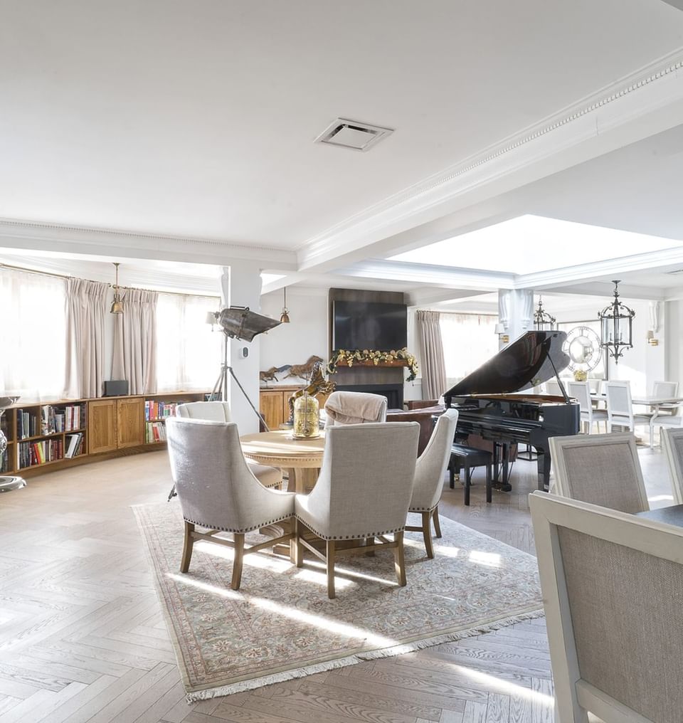 Lounge area with piano, bookshelves, and dining table in Royal Suite at Hotel Port Royal