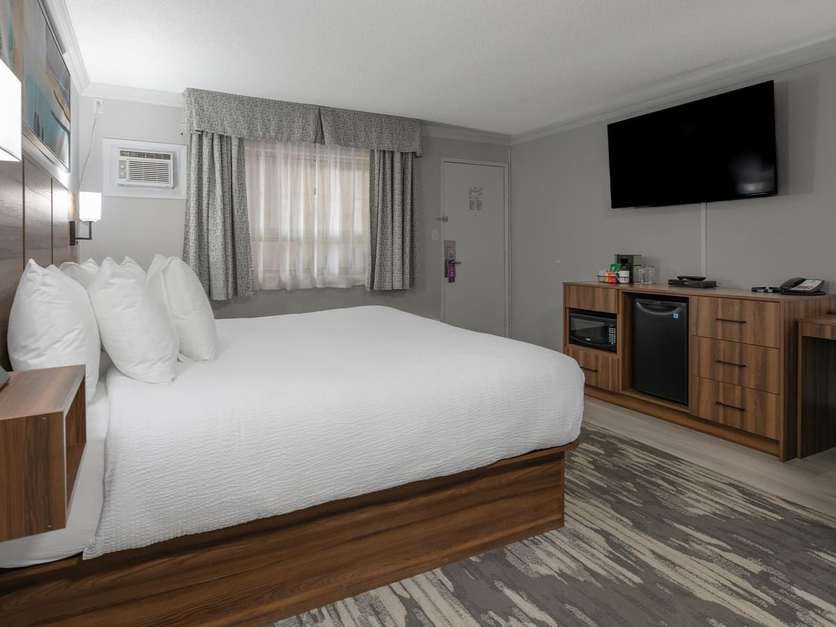 Hotel room featuring a comfortable bed, workspace, and modern amenities.