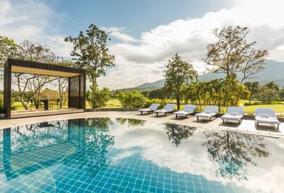 Outdoor pool with loungers at Chatrium Golf Resort