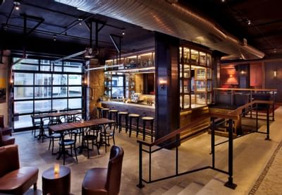 an outside eating space with tables and barstools