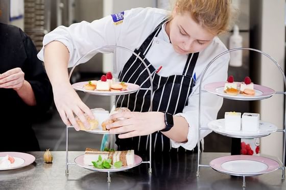 A staff member preparing food items at Richmond Hill Hotel