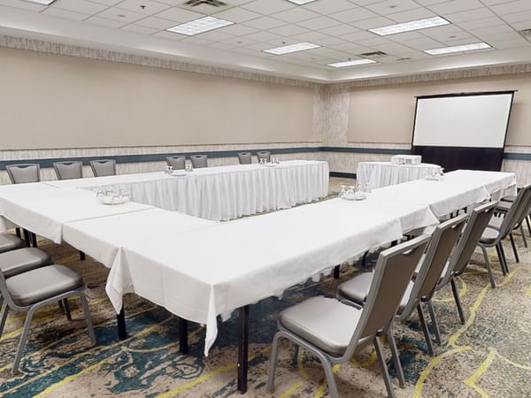 Meeting venue with project screen, chairs, and long tables