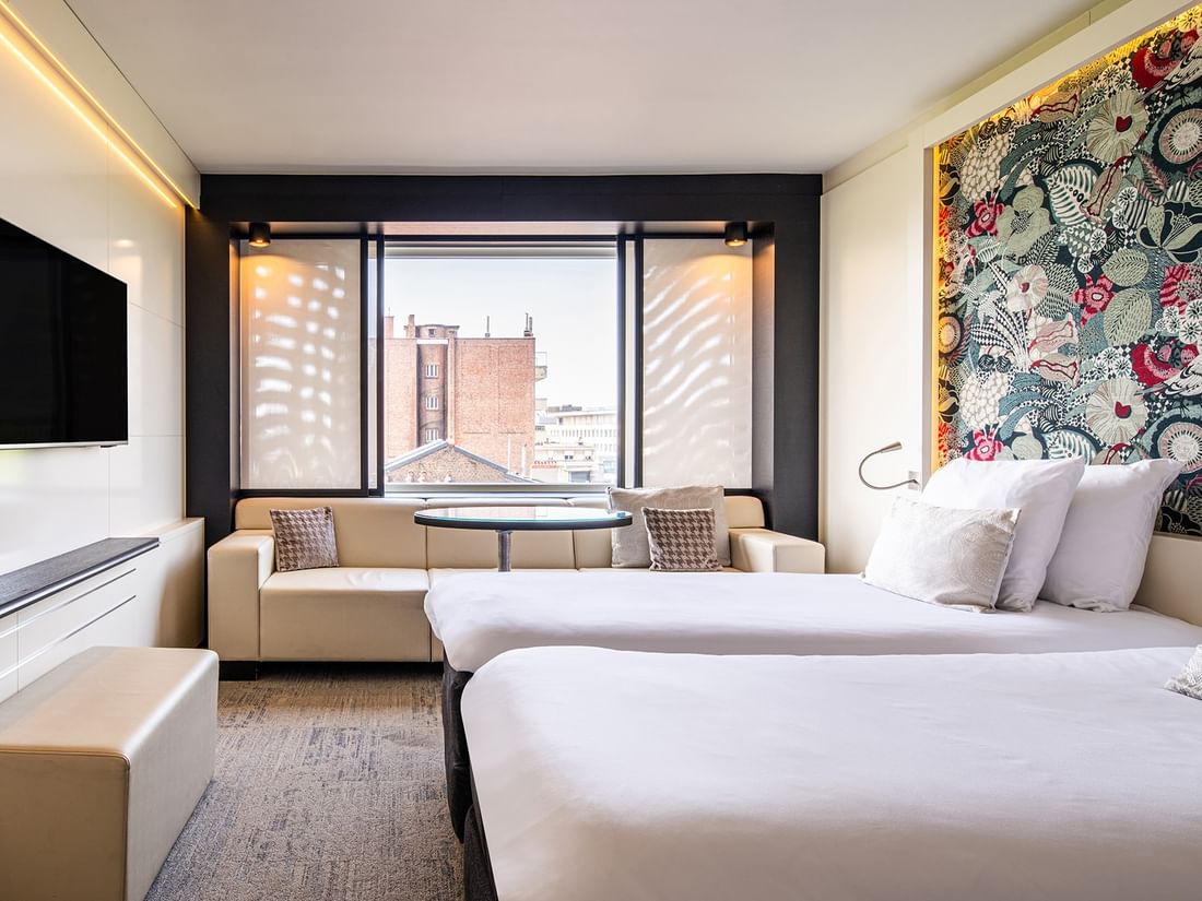 Superior Twin featuring two beds, a sofa, and a city view at The Hotel Brussels