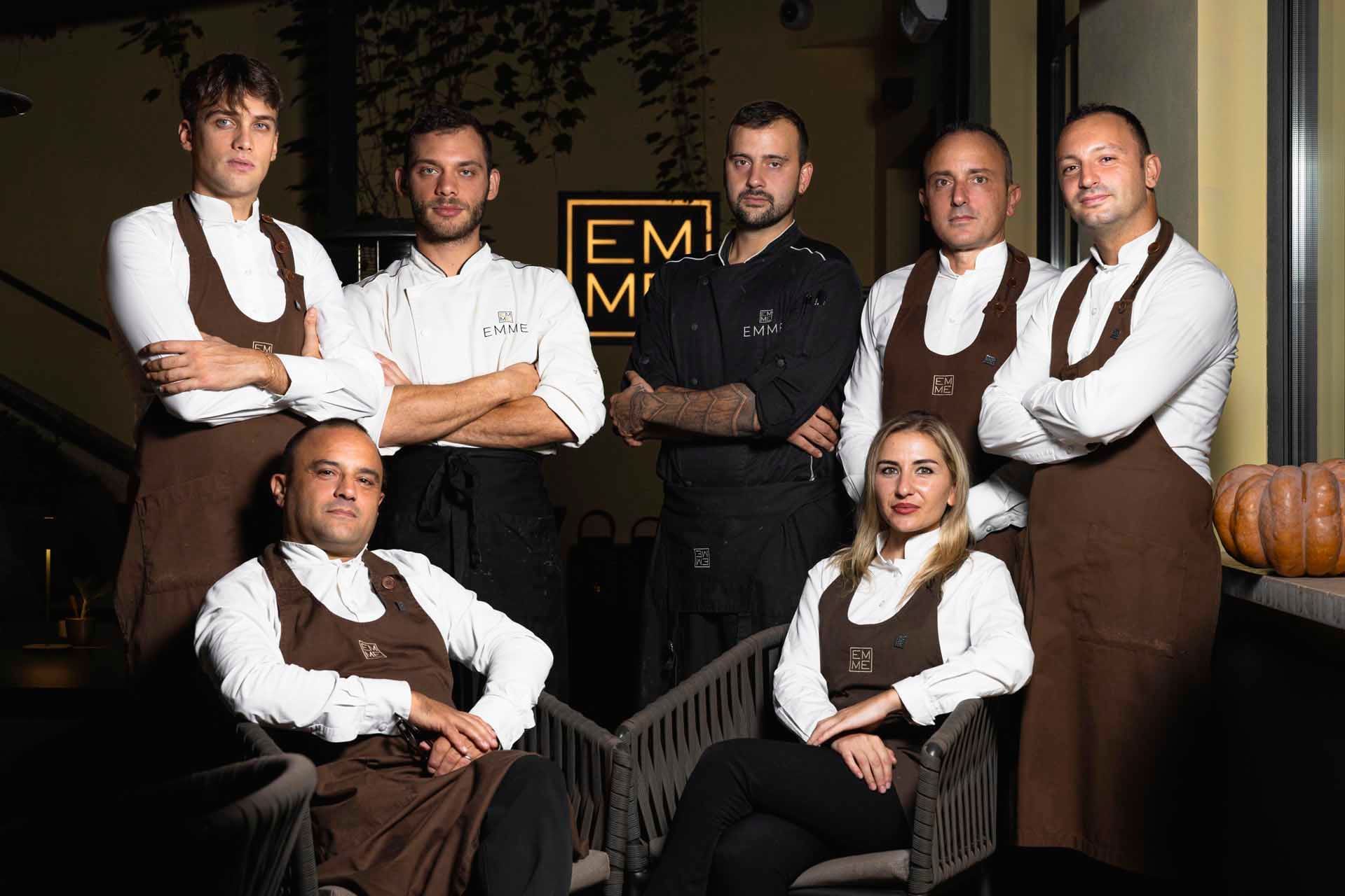 The EMME Restaurant team in a white shirt and brown aprons posing together at Margutta 19