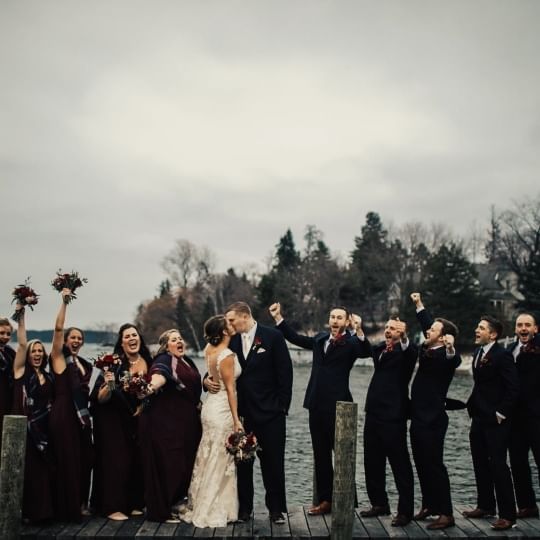 A wedding couple celebrates by the lake at Chase on The Lake