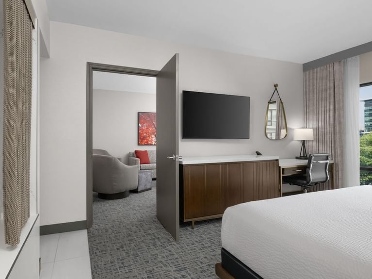 Open door leading from the Capitol Parlor Suite bedroom to a separate living area with a couch and chairs at Hotel 43 Boise