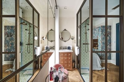 Bathroom with a circular mirror, wooden vanity, and geometric tile shower in PETIT Room at Hotel Motto Vienna