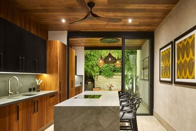 Kitchen with wooden cabinets, a kitchen island, and a view outdoor garden in Casa Cielo at Singular Signature Residences