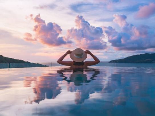 A lady in an infinity pool enjoying the evening, Momentus Hotel
