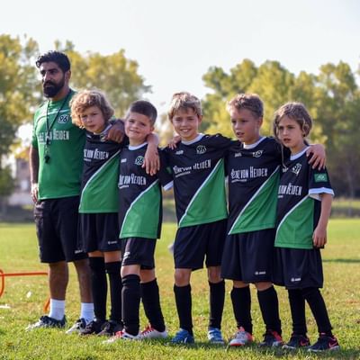 Kids of a soccer team with the coach near Falkensteiner Hotels