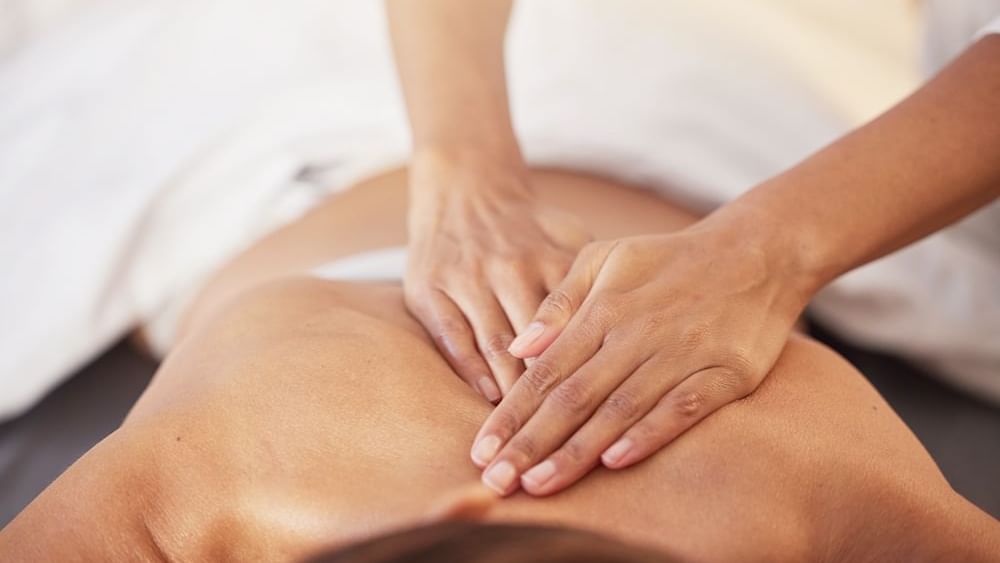 Lady having a body massage in Reflection Spa & Salon at Lake Buena Vista Resort Village & Spa