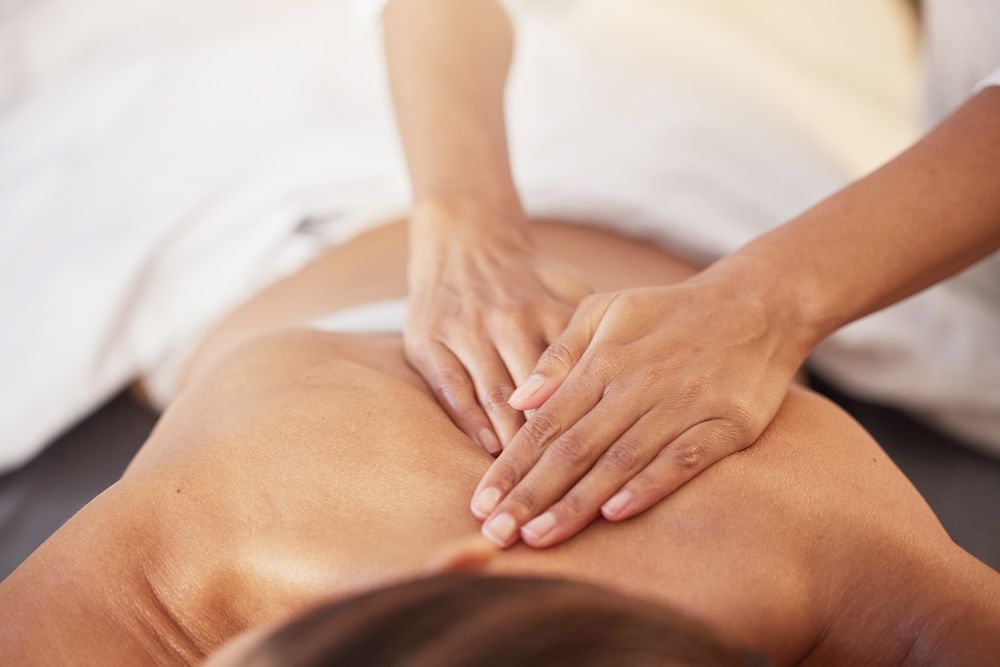 Lady having a body massage in Reflection Spa & Salon at Lake Buena Vista Resort Village & Spa