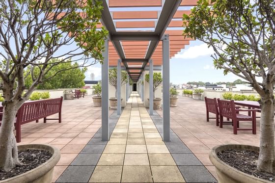 A corridor through an outdoor lounge area at Nesuto Hotels
