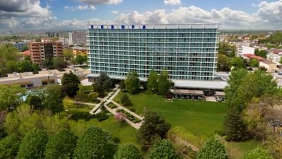 Exterior view of the Ana Hotels Europa Eforie Nord, featuring multiple glass balconies, and lush green landscaping