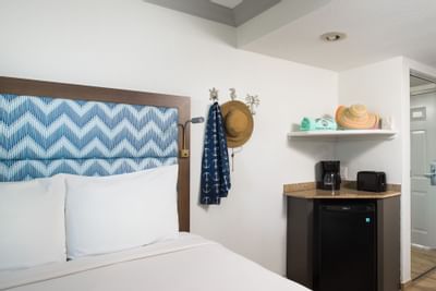a hat hanging next to a hotel bed