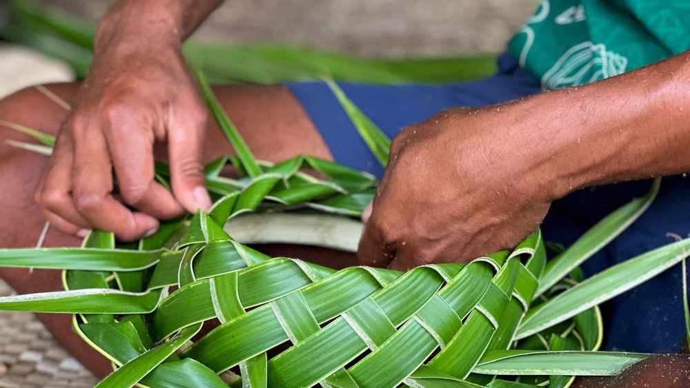 A man weaving leaves into a basket at The Naviti Resort in Korolevu, Fiji.