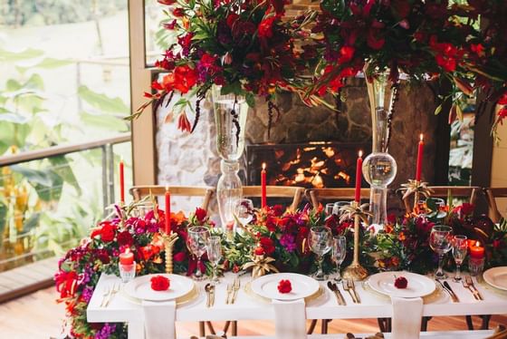 mesa de comedor profusamente decorada con cubiertos