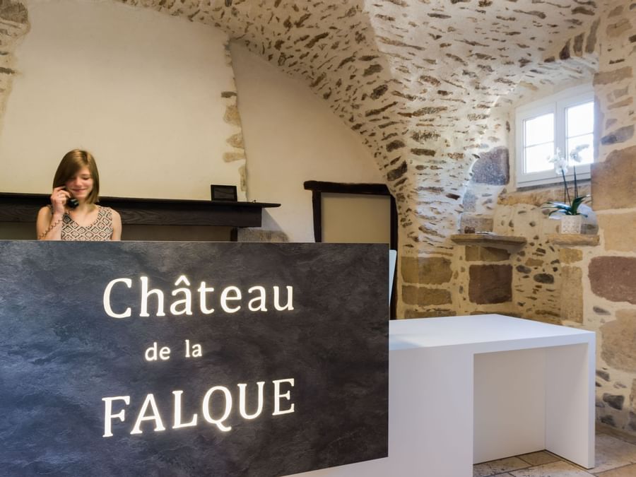 A receptionist at the reception desk in Chateau de la Falque