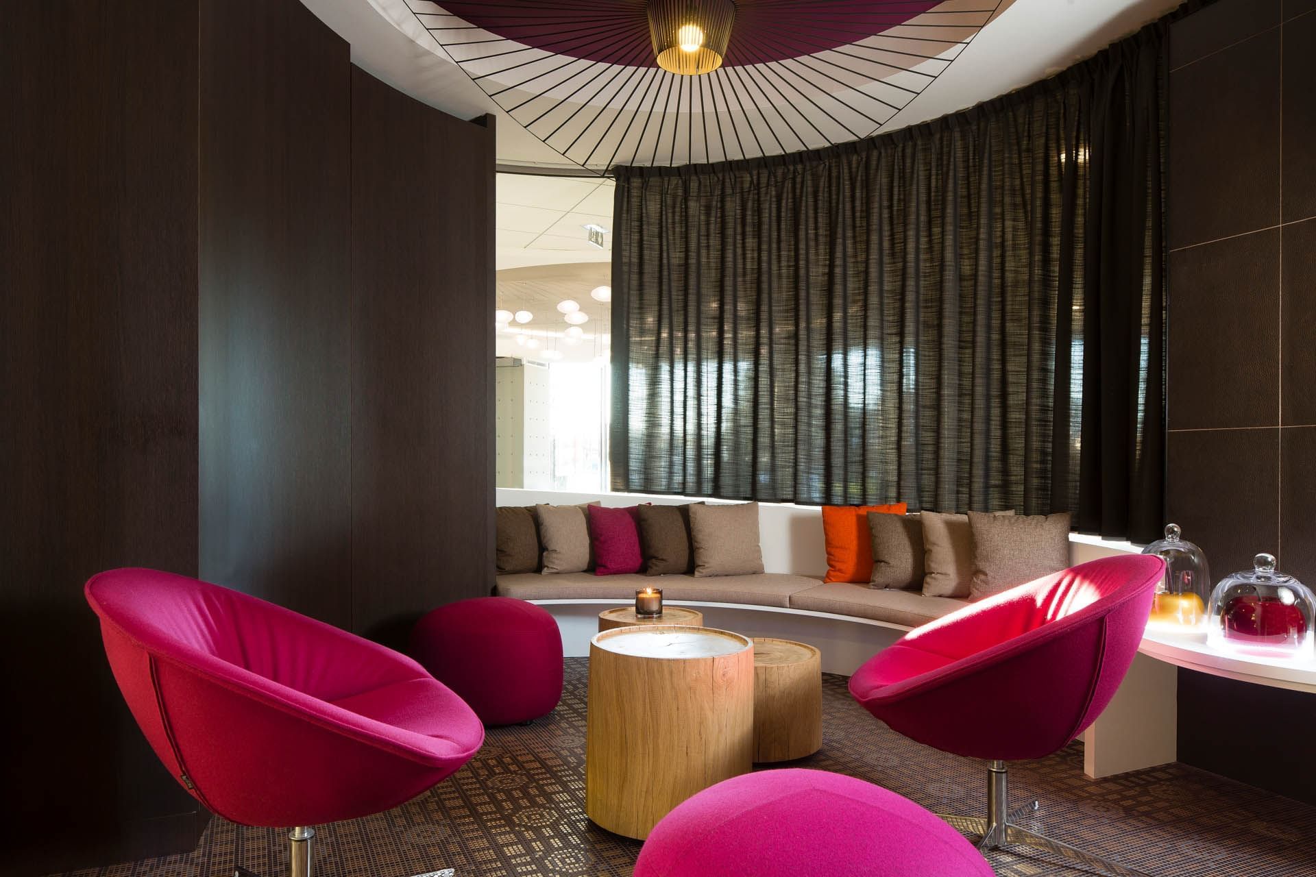 Living area with wooden stools & comfy sofas at Oceania Rennes