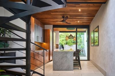 Kitchen with cabinets, a spiral staircase, and a view of an outdoor garden in Casa Cielo at Singular Signature Residence
