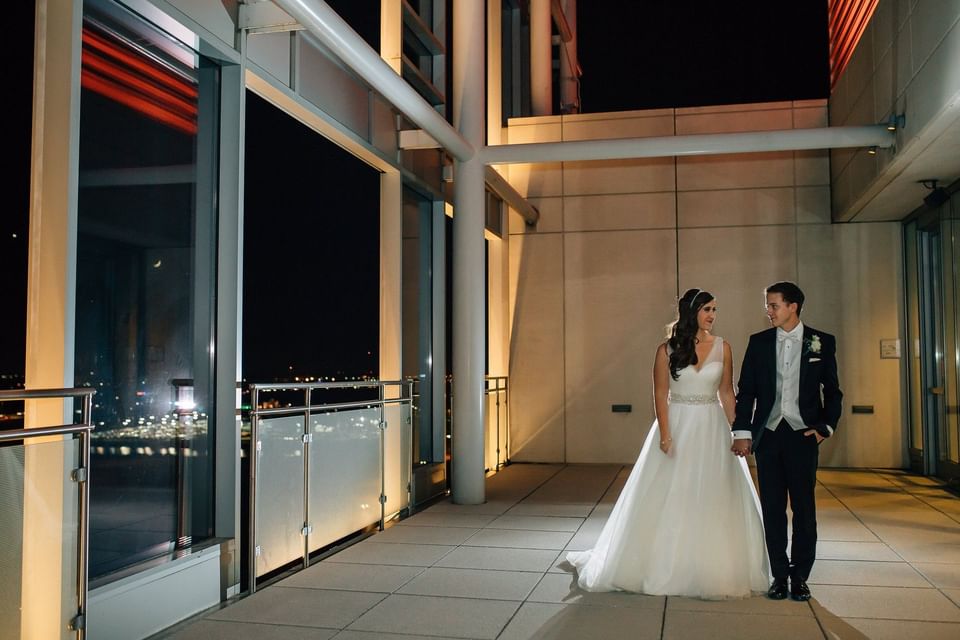 a bride and groom walk hand in hand