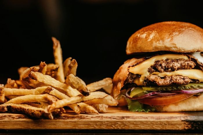Close-up of burger & fries served in a Restaurant near Anaheim Portofino Inn & Suites