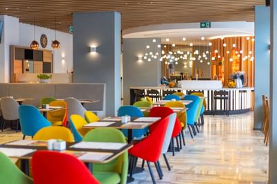 Colorful dining tables, chairs and stylish hanging lights in Metro Jazz Bar & Bistro at Metropol Hotel