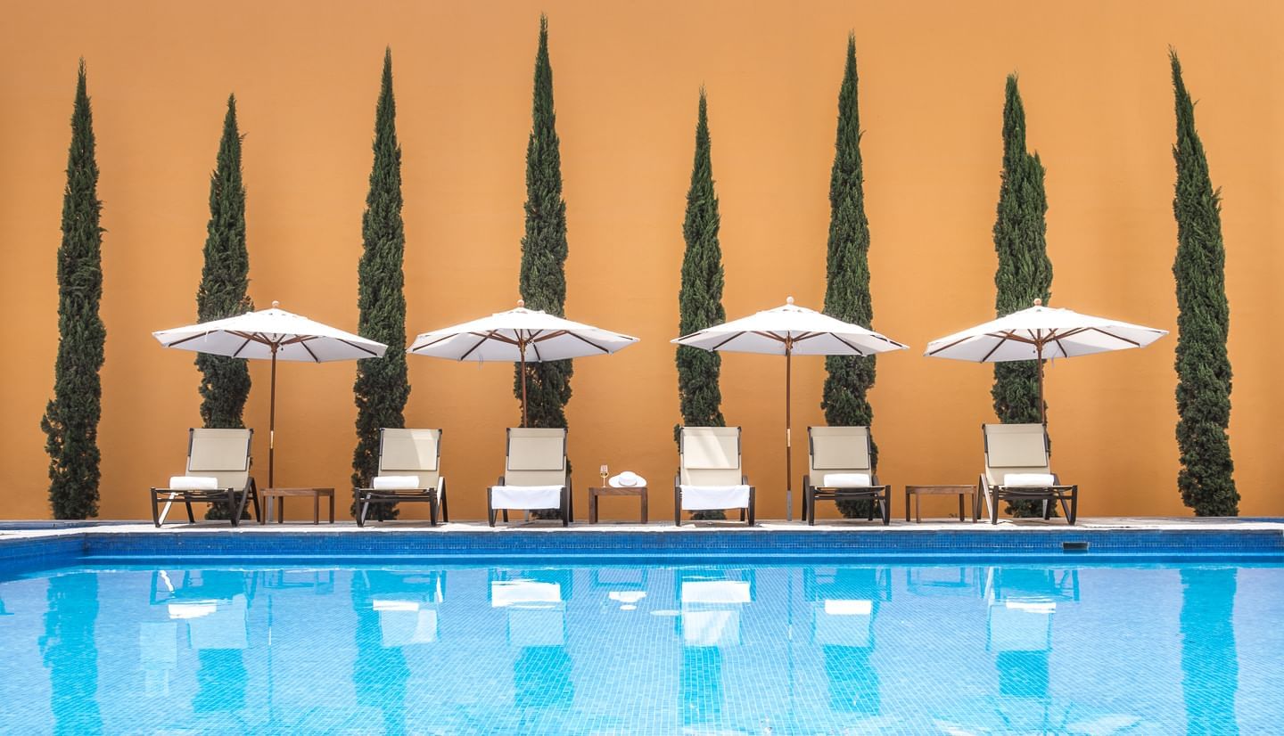 Outdoor pool with chaise lounge chair at Grand Fiesta Americana