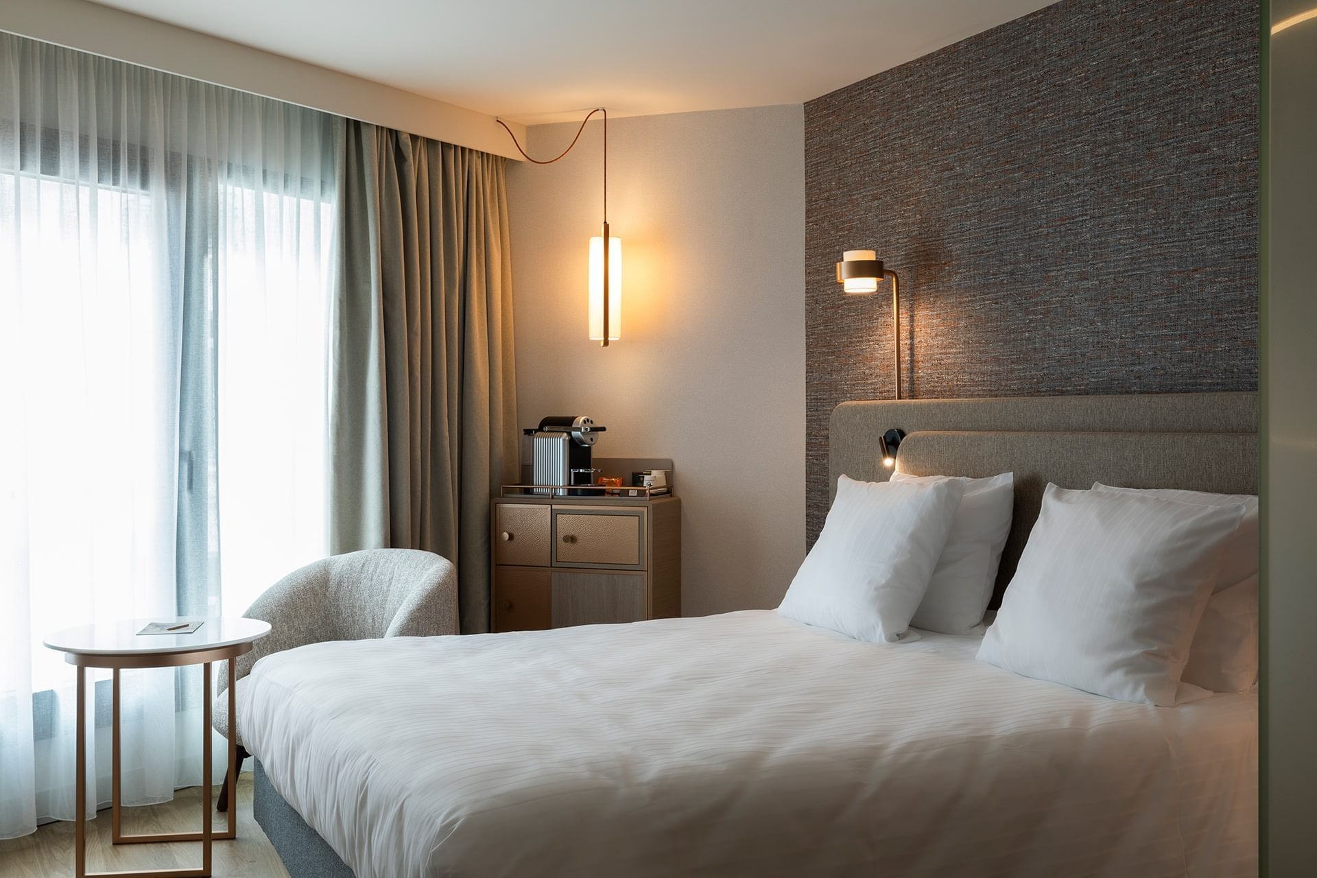 Intérieur et décor d'un lit king-size avec canapé dans une chambre à l'Oceania Saint-Malo