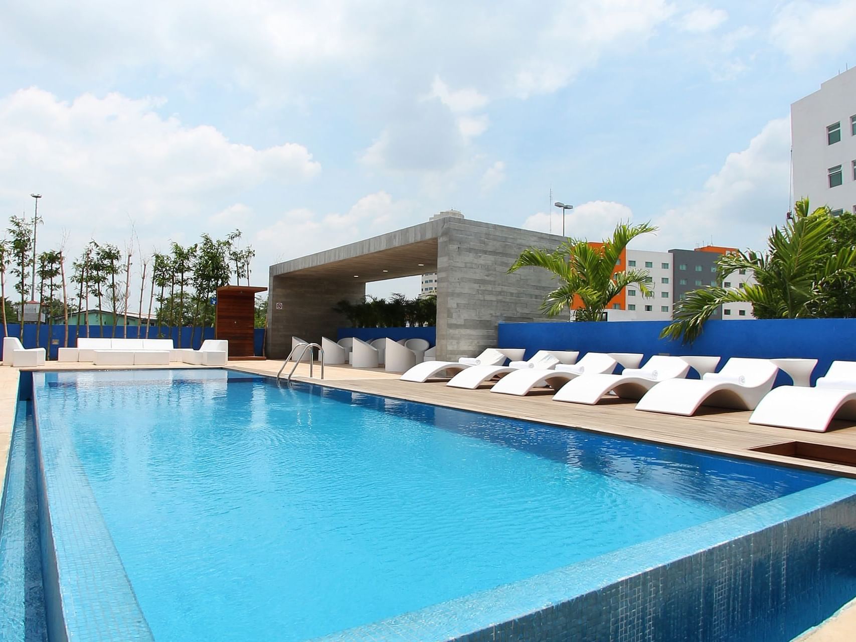 An outdoor pool with pool beds beside it at One Hotels