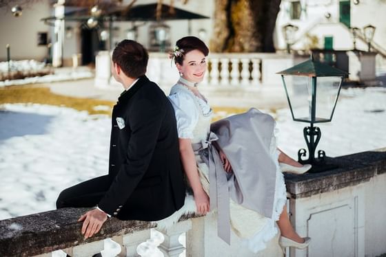 A wedding couple posing outside at Schloss Hotel in winter