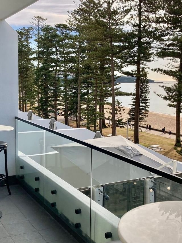 The Pacific Room at Elysium Manly, featuring black bar stools around tables near a glass railing overlooking the sea