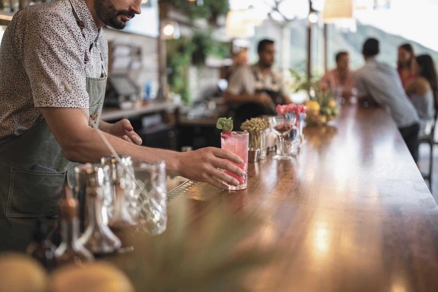 Bartender serving cocktail glasses in a restaurant near Waikiki Resort Hotel