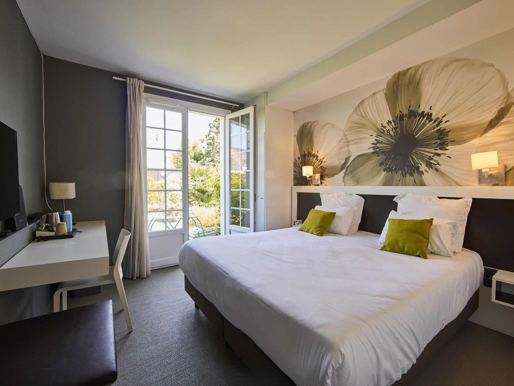 Chambre confortable avec lit blanc et bureau à l'Hôtel La Marébaudière.