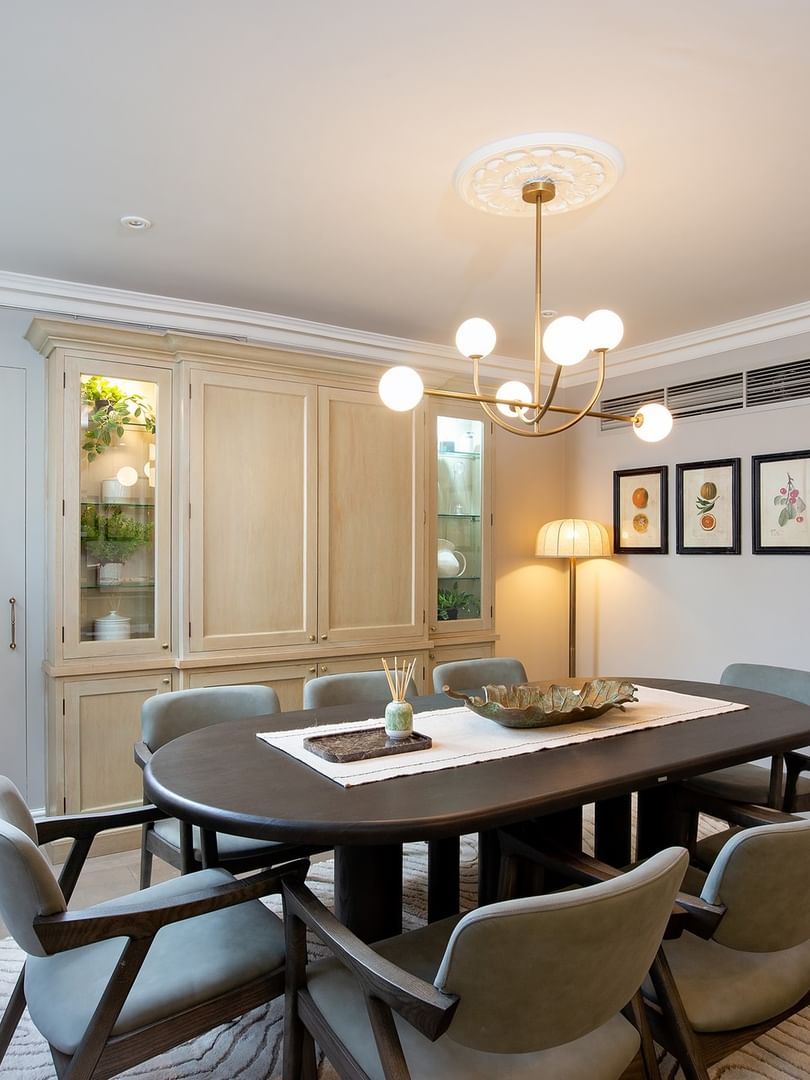Elegant dining area with a round table and chairs in the penthouse at The Capital Hotel, Apartments & Townhouse