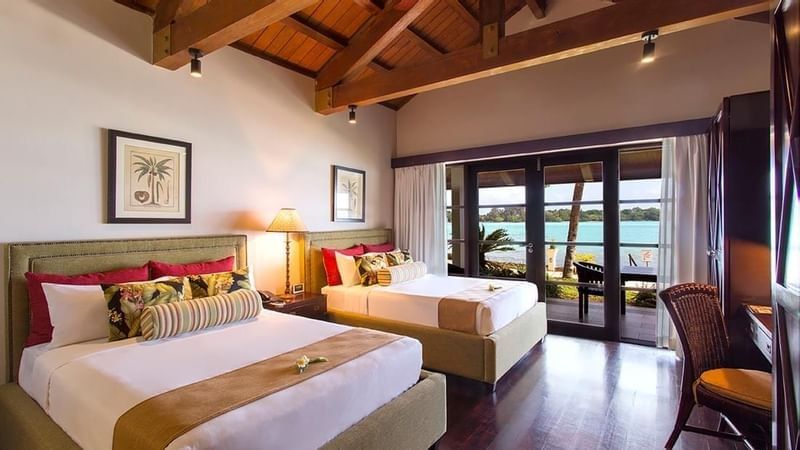 Twin bedroom with olive green bed frames and balcony view in Erakor Residence at warwick le lagon-vanuatu