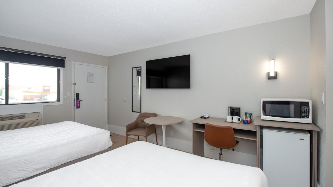 Guest room at Coast Red Deer Hotel with two queen beds, desk and TV