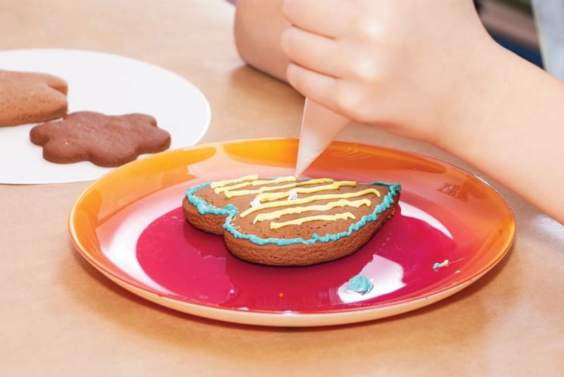 Close-up of kid piping icing on a cookie at The Diplomat Resort