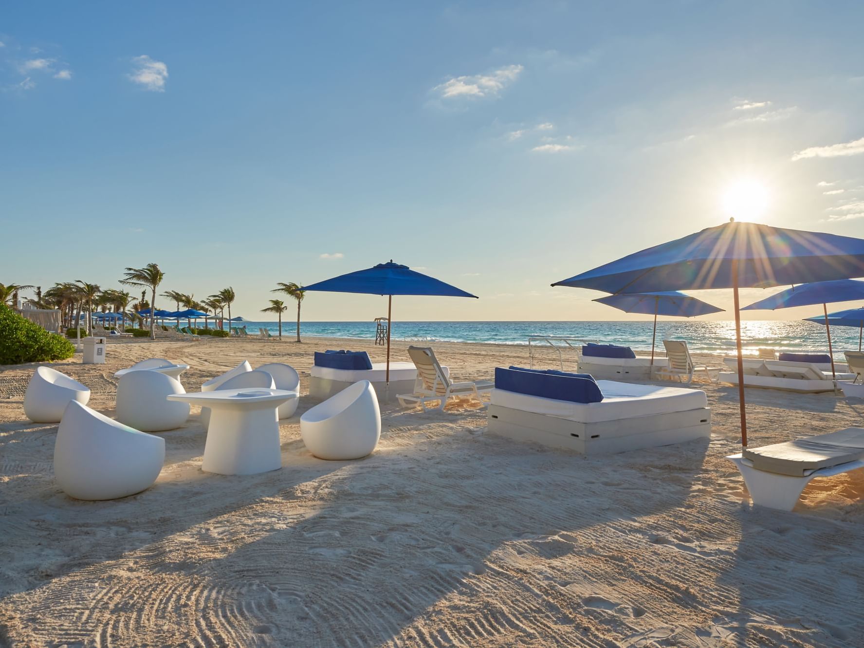 A beach with lounge chairs in the Cancún city