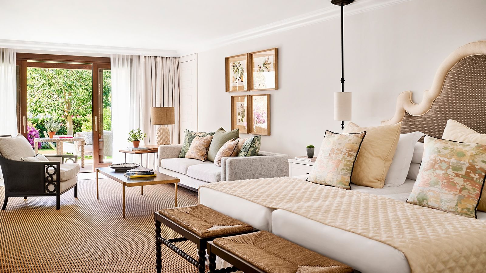 Bedroom with a four-poster bed near a chaise lounge, overlooking a garden patio at Marbella Club