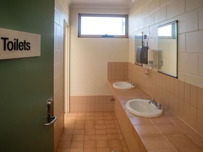 Entrance to a public restroom with two sinks and a window at La Trobe University.