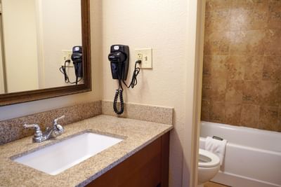Vanity and hair dryer in Deluxe King Room at Rosen Inn Closest to Universal