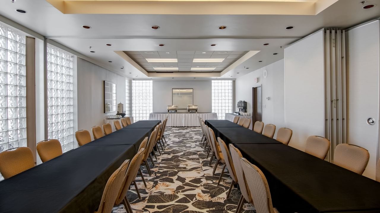 Meeting room with long tables and chairs.