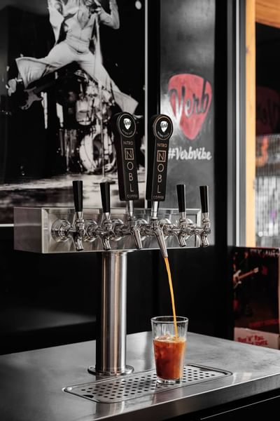 Pouring coffee into a glass in the cafe at The Verb Hotel