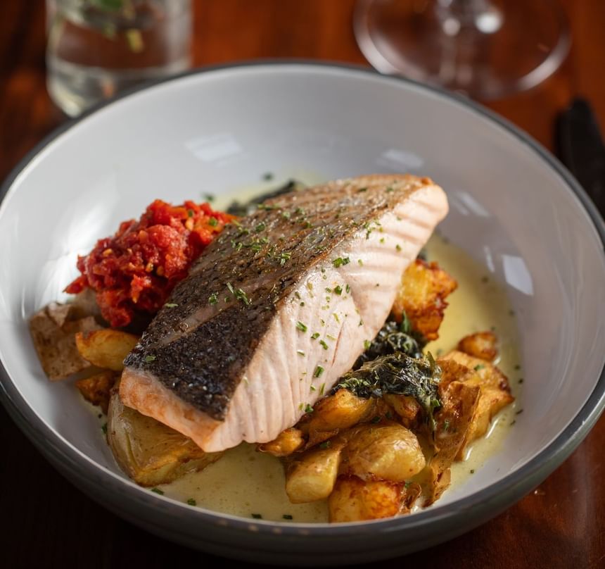 Beautifully plated salmon fillet served with roasted potatoes at Regency Restaurant in Portland Regency Hotel & Spa