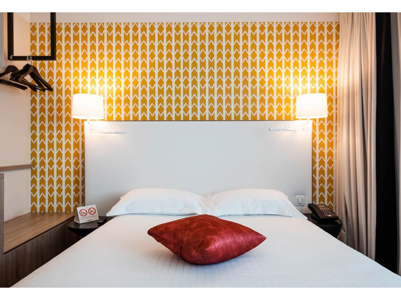 Large bed arrangement in a room at The Originals Hotels