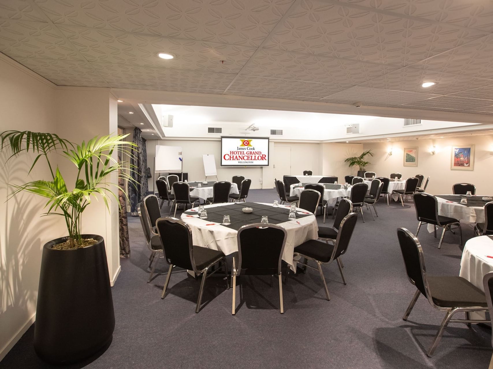 Banquet tables set-up in Chancellor 6 with carpeted floors at James Cook Grand Chancellor