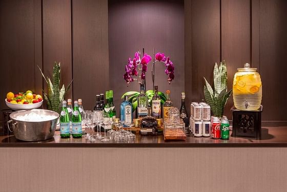 Orchids by bottled water and spirits under soft light on a dark counter at Paramount Hotel Seattle