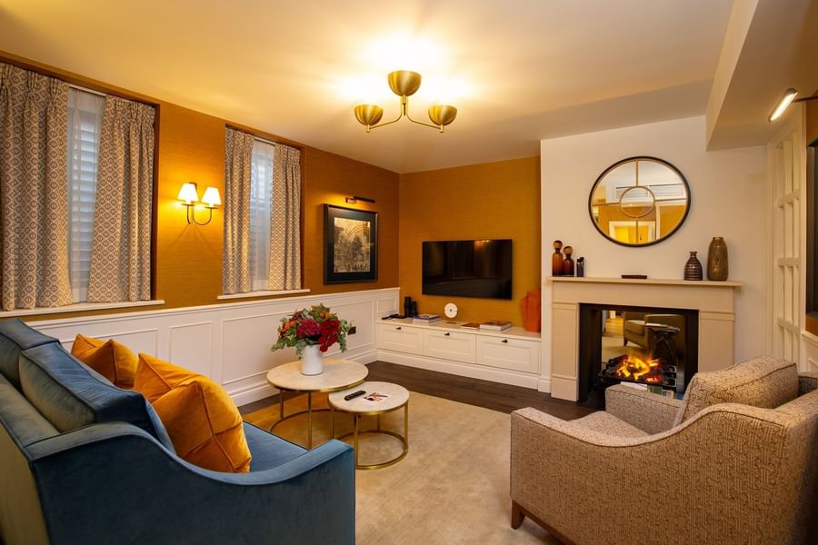 TV lounge with plush sofa near fireplace in Hyde Park Suite at The Capital Hotel, Apartments and Townhouse
