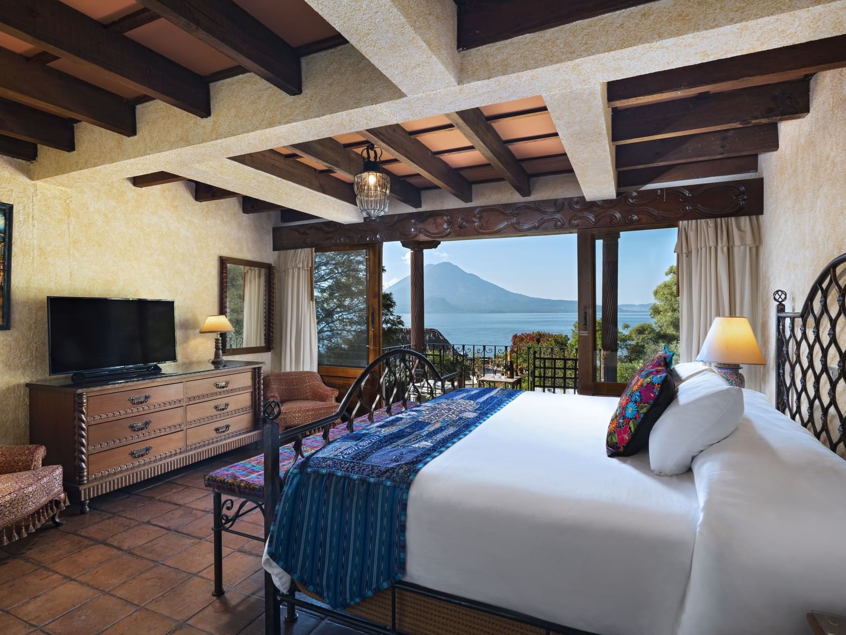 Bed, TV and lounge area in One Bed Garden View at Hotel Atitlan